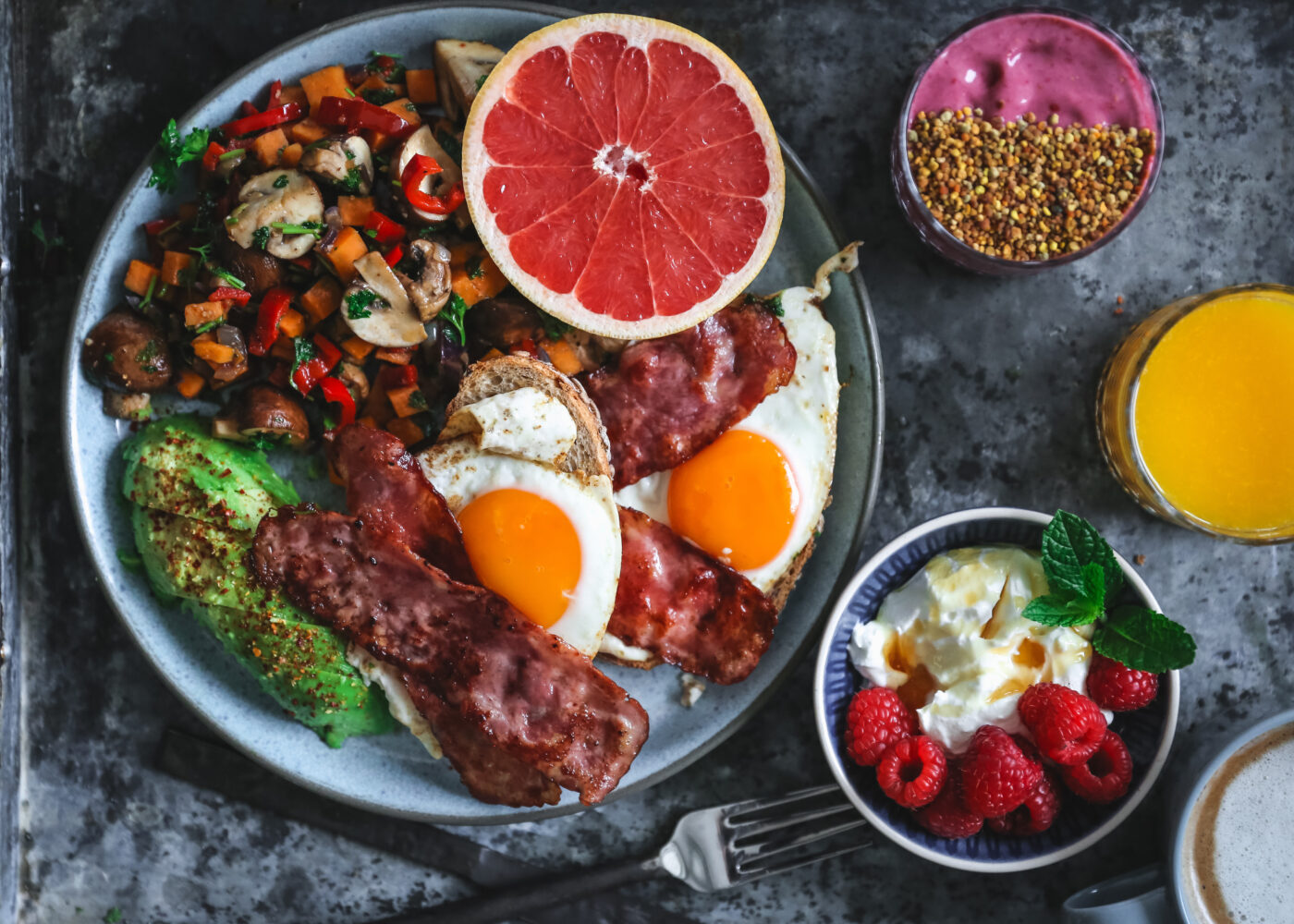 Søndagsbrunch med egg, bacon, toast, grønnsaker, frukt og bær