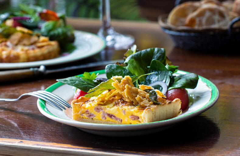 Quiche lorraine på en tallerken med salat til